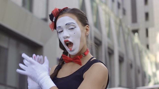 Woman mime paint her lips in front of invisible mirror