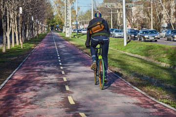 A cyclist in the city is moving along a bicycle path. Eco-friendly mode of transport