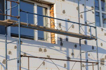Scaffold on house, renovation. House for renovation with the scaffolding for workers on building
