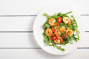 Arugula salad with prawn shrimp on white background. top wiev