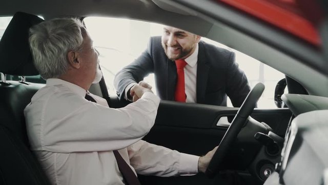 Business men. Handshake through the car window. Very professional. Looking representive.