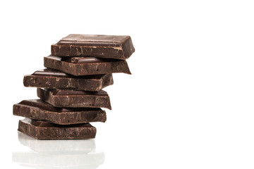Isolated dark chocolate pieces stack on white background with copy space.