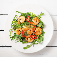 Arugula salad with prawn shrimp on white background. top wiev