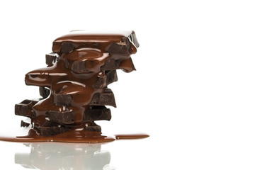 Isolated dark chocolate pieces stack with chocolate syrup on white isolated background with copy space.