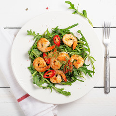Arugula salad with prawn shrimp on white background. top wiev