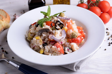 Rice salad with vegetables on white plate 
 