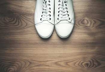 White sneakers on a wooden background.