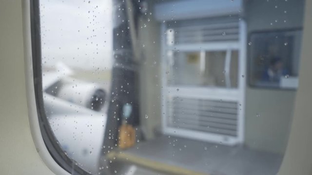 Window view with droplets Boeing 747 KLM departure from jet bridge in Schiphol