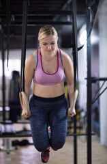 woman working out pull ups with gymnastic rings