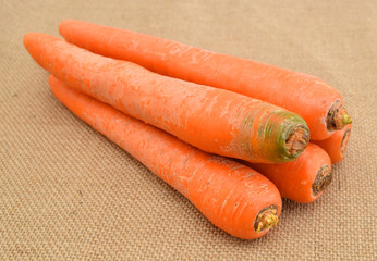 Carrot tubers isolated on burlap background