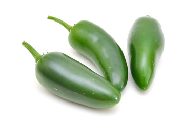 bunch of fresh green chili peppers on a white background