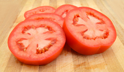 Red tomato slices on chopping board