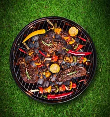 Fototapeten Barbecue grill with beef steaks, close-up. © Lukas Gojda