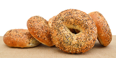 Closeup of a group of  bagels on a wood table top with burlap in the background