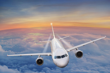 Commercial airplane flying above clouds.