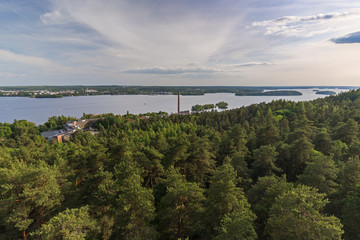 Buildings, forest at the Pyynikki ridge, Lake Pyhäjärvi and beyond in Tampere, Finland, viewed from above on a sunny day in the summer.
