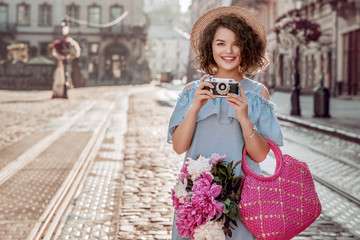 Outdoor portrait of young beautiful happy smiling woman posing in street of european city. Model...