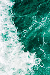 Surreal surface of the sea  waves, splash,  foam and bubbles at high tide and surf, green abstract background