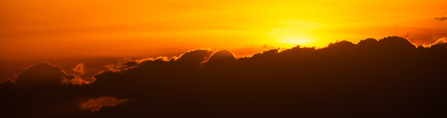 golden sky sunset with sun and black clouds