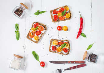 Sandwich with cream cheese, cherry tomatoes and basil.
