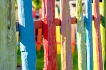 Multicolored wooden fence in the street on a sunny day.