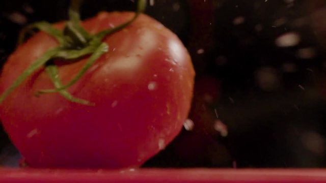 Close-up - Slow Motion - A Beautiful Red Wet Bright Tomato Falls On A Table. Concept Of Fresh Healthy Vegetables
