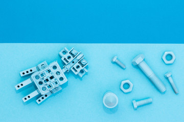 Metal robot, screws and washers, spring, colored with multicolored paint. Colorful background....