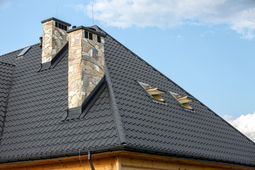  Log house in the mountains with a roof made of tiles and stone chimneys. © rzoze19