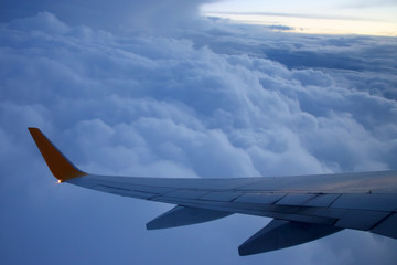 Fototapeta na wymiar Wing passenger aircraft in flight over the evening clouds