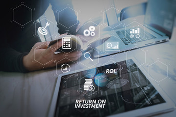 Fototapeta premium Businessman hand holding book and digital tablet.Photo finance manager working new Investment project office.Using new technology device.Graphic icons.Strategy business stock exchanges