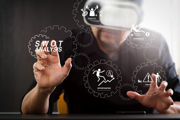 businessman wearing virtual reality goggles in modern office with mobile phone using with VR headset