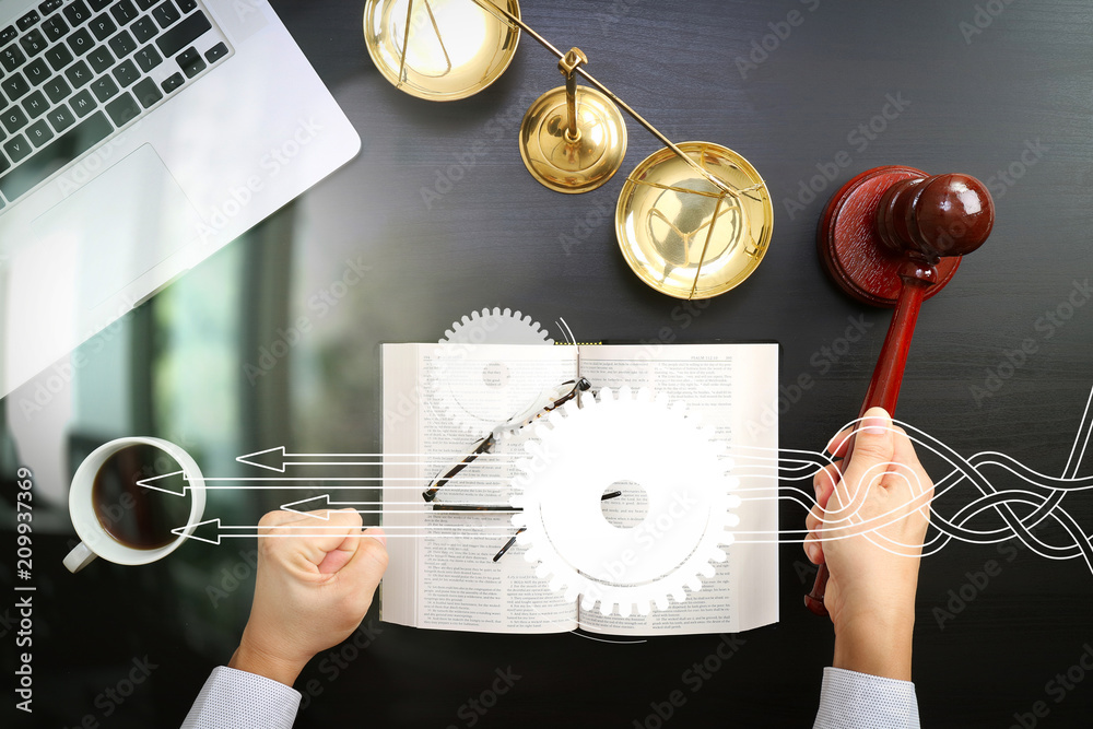 Poster justice and law concept.top view of male judge hand in a courtroom with the gavel and brass scale an