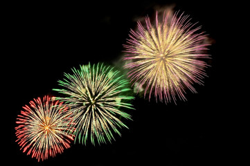 Flashes of fireworks of green, red, purple and gold color