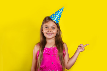 Studio portrait of a little girl wearing a party hat on her birthday