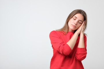 Young caucasian woman in red clothes wanting to sleep. She has no energy