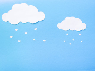 Paper clouds from which the paper hearts fall.