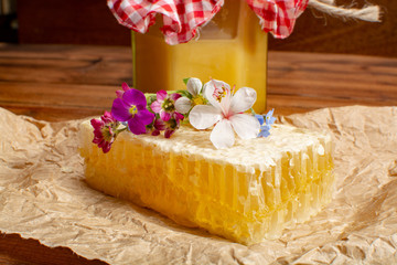 Obraz na płótnie Canvas Homemade organic honey in honeycomb from farm apiary on mountains meadows with summer wild flowers