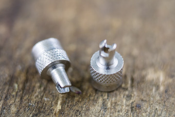 Inner tube valve on a wooden workshop table. Accessories for vulcanizer for repairing inner tubes and car tires.