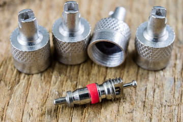 Inner tube valve on a wooden workshop table. Accessories for vulcanizer for repairing inner tubes and car tires.