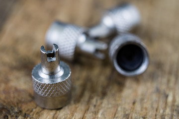 Inner tube valve on a wooden workshop table. Accessories for vulcanizer for repairing inner tubes and car tires.