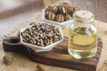 seeds and castor oil on the wooden table - Ricinus communis