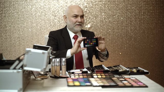 Professional makeup artist showing holding colorchecker