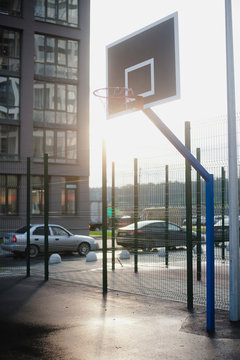 Street basketball court and basketball Hoop on sunset background.
