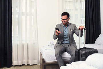 Businessman sitting in his hotel room unpacking