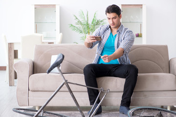 Young man repairing bicycle at home
