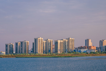 Fototapeta na wymiar Urban landscape of commuter town on river bank in Kazan, Russia