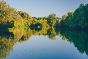 Forest blue lake at autumn sunset.