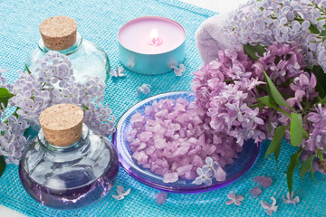 Obraz na płótnie Canvas Aroma SPA set / Aromatherapy essential oil in glass bottle, sea salt, aroma candle and lilac flower 