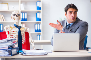 Businessman working with skeleton in office
