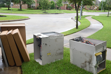 Old gas furnace units sitting at curb after technician has replaced units with new heaters